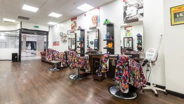 The shop floor: barber chairs with bright capes and mirrored stations