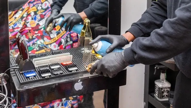 Gloved hands cleaning clippers at the station